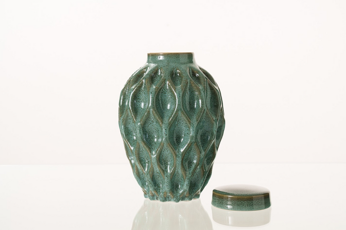 Teal Echo 3D printed ceramic urn with a flowing teardrop lattice pattern and a lid placed beside it.
