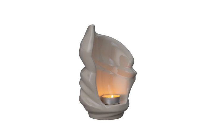 Creamy white twisted ceramic candle urn with a large hollow opening and a small lit tea light inside