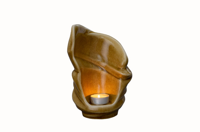 Open interior of Light Ceramic Urn with tealight candle glowing inside the warm brown glaze.